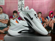Angled view of the white and black Nike A'ja sneaker pair displaying the side profiles and soles.