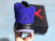 Rear view of the sneaker showing the black Jordan logo on the purple heel and translucent outsole.