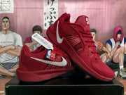 Pair of red Nike basketball sneakers with white Swoosh branding displayed on a black shoebox.
