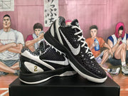 Black and white basketball sneakers shown from an angled side and top view, highlighting the textured toe box, white laces, and patterned collar lining.