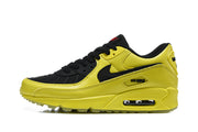 Side view of a yellow and black Nike Air Max 90 sneaker with a visible midsole Air unit.