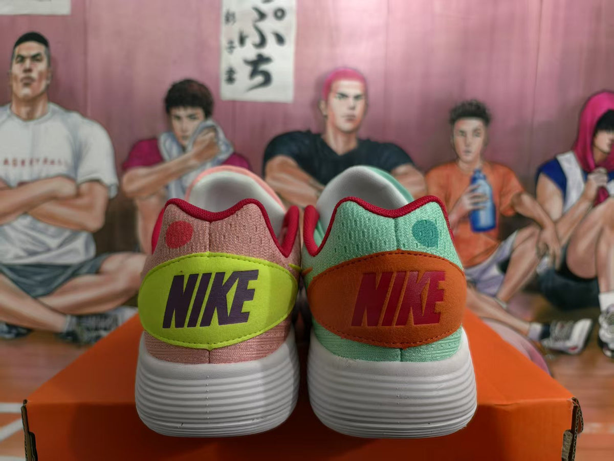 Rear view of pink and mint Nike sneakers with contrasting heel panels and white ribbed outsoles.