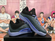 Angled view of the paired black and purple basketball sneakers displayed on a shoe box.