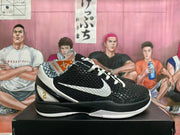 Side view of black and white basketball shoe with textured upper, white Swoosh, and gold number 2 detail.