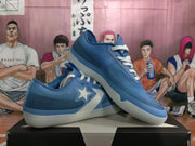 Angled view of two blue star-and-chevron sneakers displaying the textured upper, white laces, and translucent rubber outsoles.