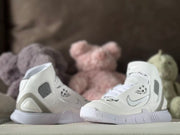 Front three-quarter view of the white high-top sneaker pair with strap closures and graphic details.