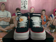 Front view of navy and white high-top sneakers with white laces, red trim, and padded tongues.