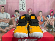 Front view of yellow and black Nike sneakers showing the toe panels and forefoot straps