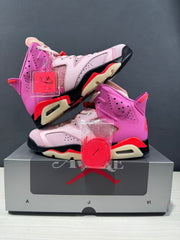 Angled product view showing both sneakers, red spare laces, and hanging accessories.