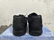 Rear view of an all-black pair of Nike basketball shoes