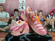 Three-quarter view of pink and orange Nike sneakers showing orange laces, pink detailing, and side Swooshes.