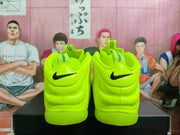 Rear view of the fluorescent green sneakers showing black Swoosh details, padded heel collars, pull tabs, and the outsole shape.