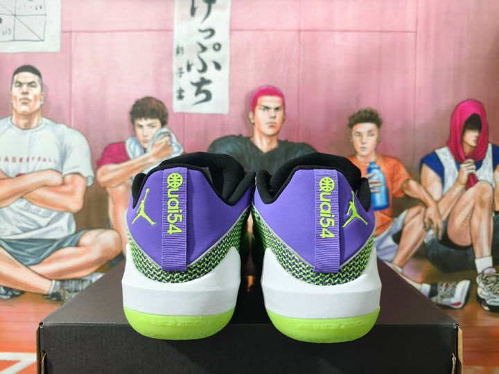 Rear view of purple and green Jordan basketball sneakers on a black shoebox, showing heel branding and bright green outsoles.
