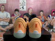 Rear view of orange-toned Jordan sneakers with black collars, light gray heel details, and translucent-looking outsoles.