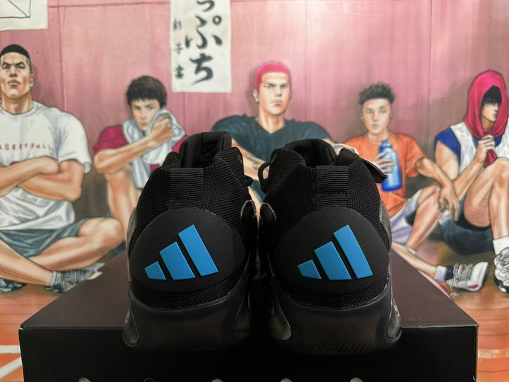 Rear view of black adidas sneakers showing blue heel logos, black mesh collars and a basketball-themed illustrated background.