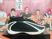 Side profile of a black sneaker with white overlays and a pale outsole