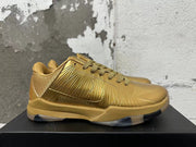 Side profile of a gold Nike Kobe 5 shoe