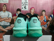 Rear view of lake-green basketball shoes with GT heel emblems and textured soles