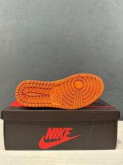 Close view of the orange rubber outsole with circular and grid traction details.