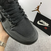 Close-up of the black textured toe box, black laces, and tonal stitching.