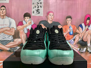 Front view of a pair of mint green and black Nike sneakers with black laces and translucent toe outsoles.
