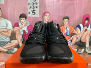Front view of black Nike basketball sneakers showing textured toe boxes, cross-lace details and patterned outsoles.