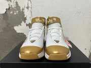 Front view showing the white laces, metallic-gold toe accents, and ankle straps.
