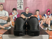 Rear view of black Nike sneakers showing ribbed heel panels and textured black outsoles.