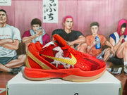 Side view highlighting the red upper, patterned side graphic, gold heel detail, and translucent outsole.