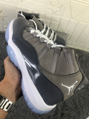Angled close-up of the lacing system, grey upper panels, glossy overlay, and Jordan tongue branding.
