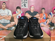 Front view of black Nike sneakers showing mesh uppers, laces, tongue branding and white speckled midsoles.