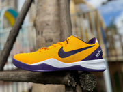 Side profile of a gold Kobe 8 shoe with purple and white details