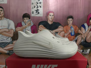 Side profile of a white perforated clog with sculpted ridges and a Nike logo