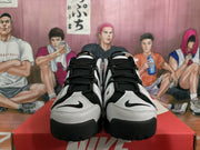 Front view of black and white Nike sneakers with black laces, contrast panels, and swoosh details.
