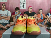 Front view showing orange laces and yellow-orange uppers on Nike basketball shoes