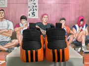 Rear view of black and orange sneakers showing ribbed black heel panels and orange-and-black vertical outsole details.