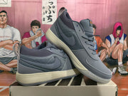 Angled view of gray Nike low-top sneakers displayed together, showing the Swoosh, padded collars, pull tabs, and contrasting midsoles.