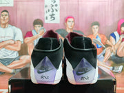 Rear view of black and white basketball shoes with purple heel details.