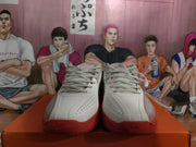 Front view of gray Nike basketball sneakers with laces, perforated toe panels, and red rubber outsoles.