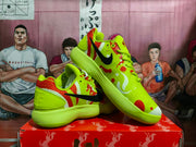Angled view of the pair highlighting the yellow upper, red patterned panels, black Swoosh, and textured soles.