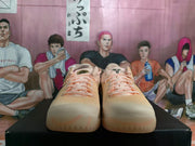 Front view of peach-colored basketball shoes with pale laces and light-colored soles.