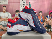 Three-quarter view of the white, navy blue, and red sneakers displayed together, showing the layered upper and outsole.