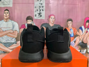 Rear view of the black sneakers showing the padded heels and fabric pull tabs.