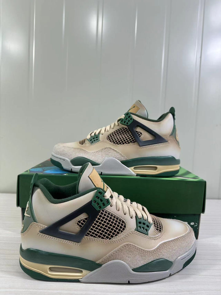 Pair of off-white, green and navy Air Jordan 4 Retro sneakers shown from angled side views on a green illustrated shoebox.