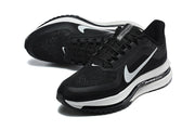 Pair of black Nike Pegasus shoes shown from above at an angle, with white Swoosh accents and textured uppers.