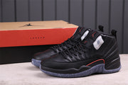 Pair of black Air Jordan 12 sneakers beside a Jordan shoebox.