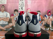 Rear view of the pair showing gray heel panels, navy collar sections, red outsole details, and metallic accents.