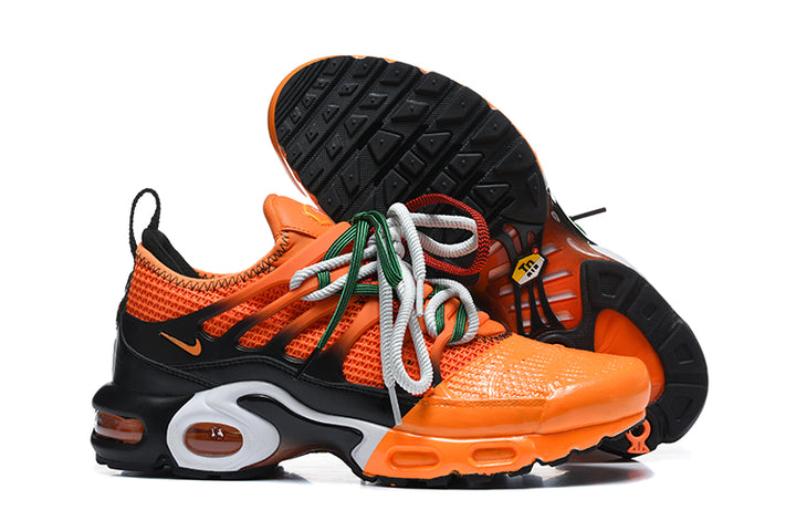 Orange and black Nike Air Max Plus sneakers shown from the side with the outsole visible.