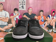 Front view of black lace-up Jordan sneakers with red tongue logos and contrasting midsoles.