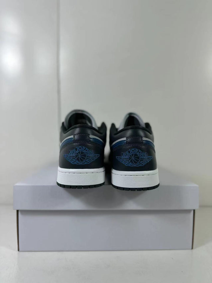 Rear view of black, grey, and blue low-top sneakers showing blue heel branding and white midsoles.